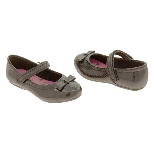 Girls Black School Shoes. Black Mary Jane shoes with a moc croc detail and a bow to the front. Black touch fasten strap over the foot and a pink insole. Both shoes facing top to tail.