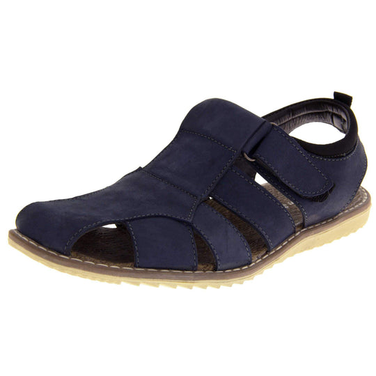 Mens leather sandals. Classic sandal with a navy blue leather upper. Closed toe but with straps to give a cut outs down the side to keep feet cool. Touch close fastening ankle strap. With a brown insole and sand coloured outsole. Left foot at an angle.