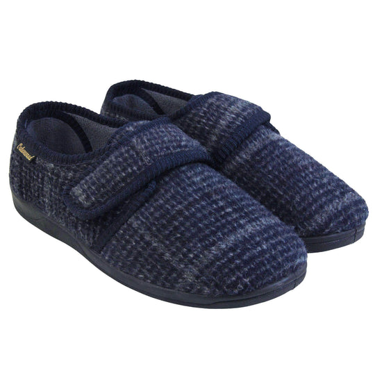 Adjustable memory foam slippers. Mens full back slippers with a blue check upper and blue edging around the strap and collar of the shoe. Touch fasten strap across the bridge of the foot. Chunky black synthetic sole. Both feet together from a slight angle.