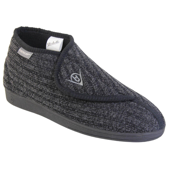 Orthopaedic slippers for men. Mens orthopaedic slippers in an ankle boot style. With a black knit upper and black fleece lining. With an adjustable touch close top with a grey Dunlop logo on. Small grey label to the outer side edge with Dunlop written on. Thick black outdoor sole. Right foot at an angle.