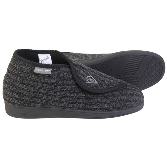 Orthopaedic slippers for men. Mens orthopaedic slippers in an ankle boot style. With a black knit upper and black fleece lining. With an adjustable touch close top with a grey Dunlop logo on. Small grey label to the outer side edge with Dunlop written on. Thick black outdoor sole. Both feet from side profile with the left foot on its side to show the sole.