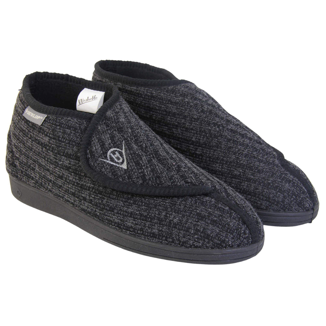Orthopaedic slippers for men. Mens orthopaedic slippers in an ankle boot style. With a black knit upper and black fleece lining. With an adjustable touch close top with a grey Dunlop logo on. Small grey label to the outer side edge with Dunlop written on. Thick black outdoor sole. Both feet together at an angle.