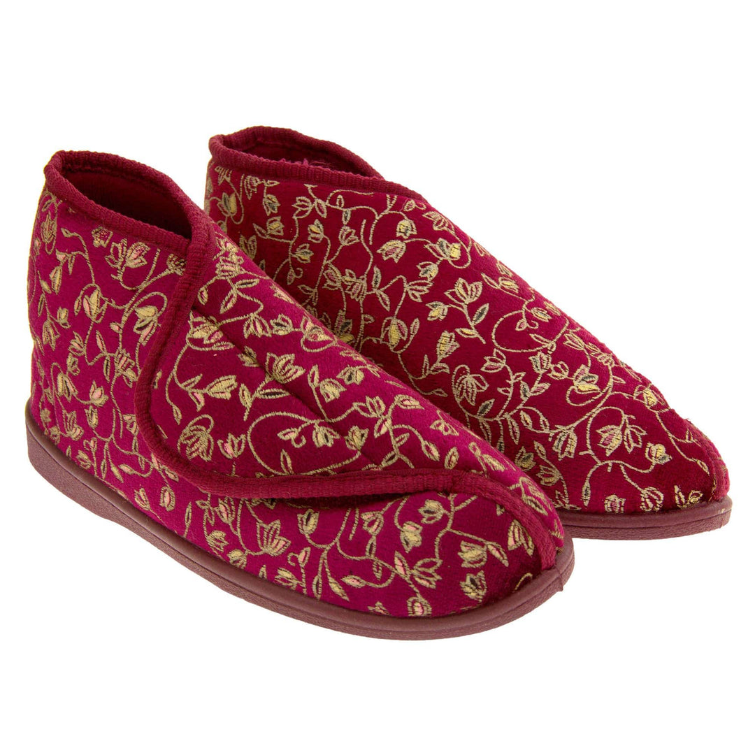 Ankle boot slippers. Womens bootie style slipper with a burgundy textile upper with vine and flower embroidered design and red edging. Touch fasten tab to the top and red textile lining. Firm red sole. Both feet together at angle.