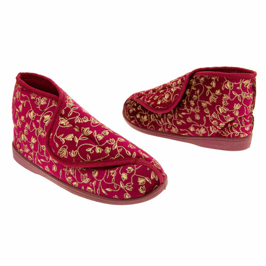 Ankle boot slippers. Womens bootie style slipper with a burgundy textile upper with vine and flower embroidered design and red edging. Touch fasten tab to the top and red textile lining. Firm red sole. Both feet at an angle, facing top to tail.