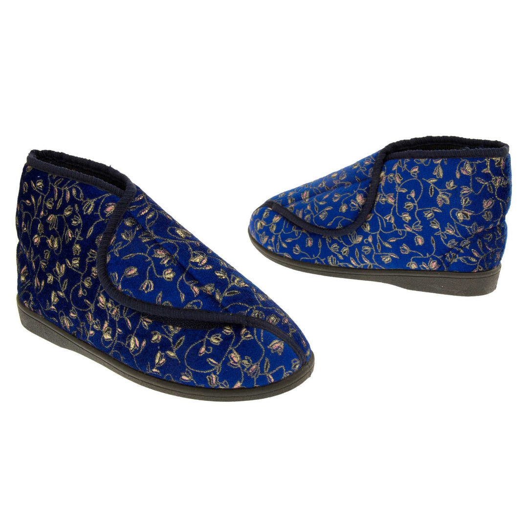 Ankle slippers. Womens bootie style slipper with a navy blue textile upper with vine and flower embroidered design and black edging. Touch fasten tab to the top and blue textile lining. Firm black sole. Both feet at an angle, facing top to tail.