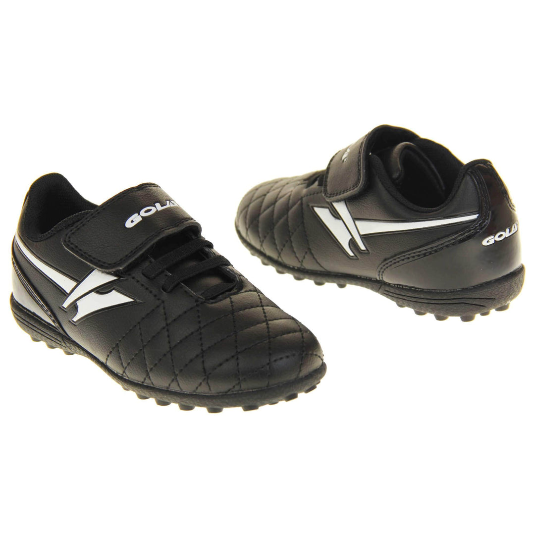 Astro turf boots. Black football trainers with stitching detail to the toes to give a quilted appearance. The touch close fastening and elasticated lace detail to the front. White Gola logo to the side and white Gola branding to the touch fasten strap. Black sole with small Astro turf studs to the base. Both feet facing top to tale from an angle.