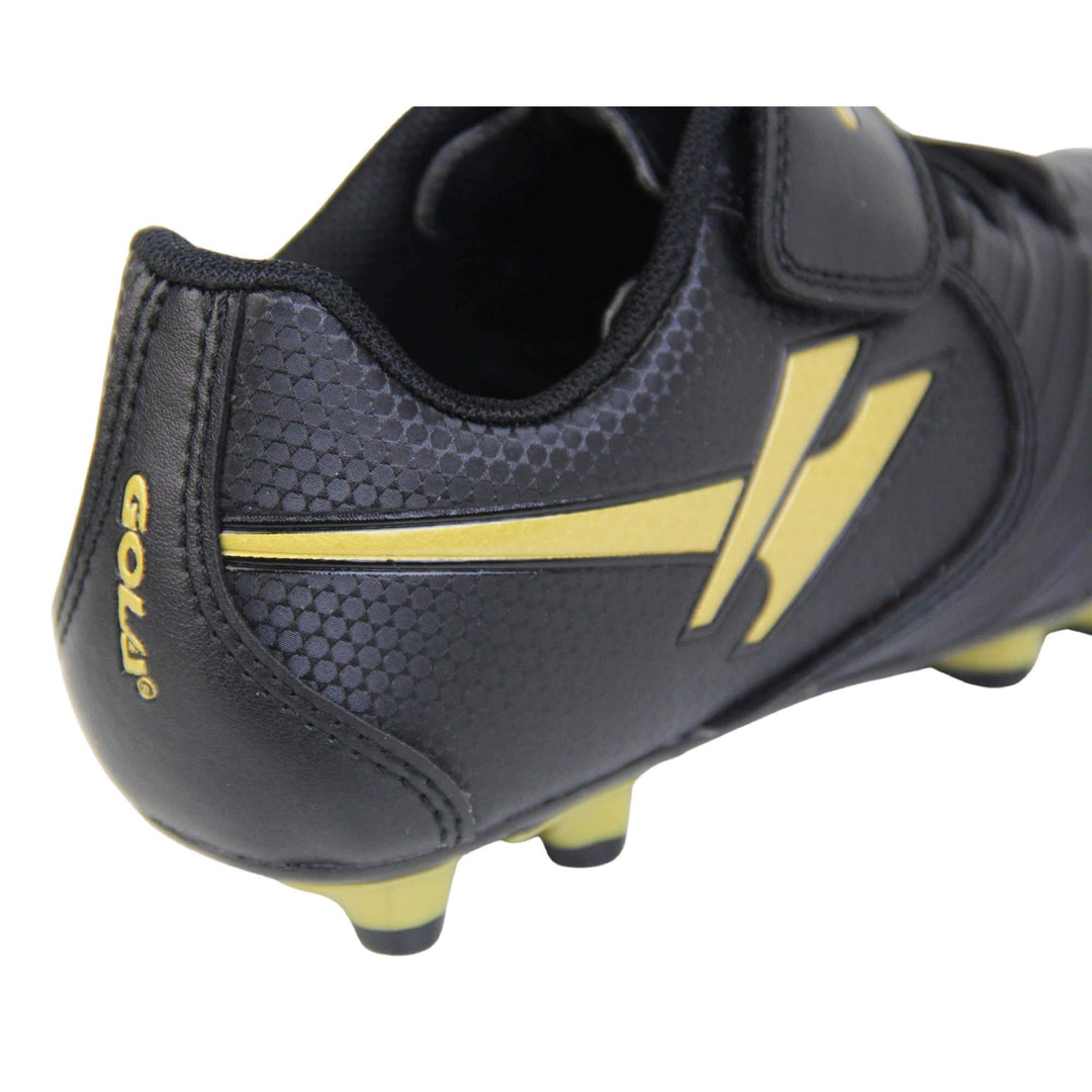 Kids football boots. Black football boots with line detailing to the toes. Touch close fastening and elasticated lace detail to the front. Gold Gola logo to the side and gold Gola branding to the touch fasten strap. Black sole with gold accents and studs to the base. Close up of back of shoe to shoe the Gola logo and gold Gola branding to the back of the shoe.