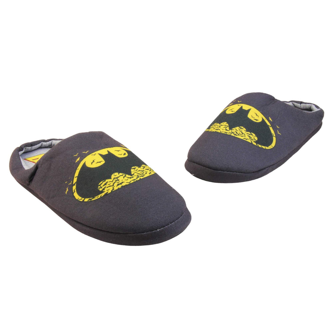 Batman slippers mens. Mule style slippers with black textile upper with a yellow Batman logo on the top. Grey textile lining and firm black sole. Both feet in a wide V shape with the toes almost touching.