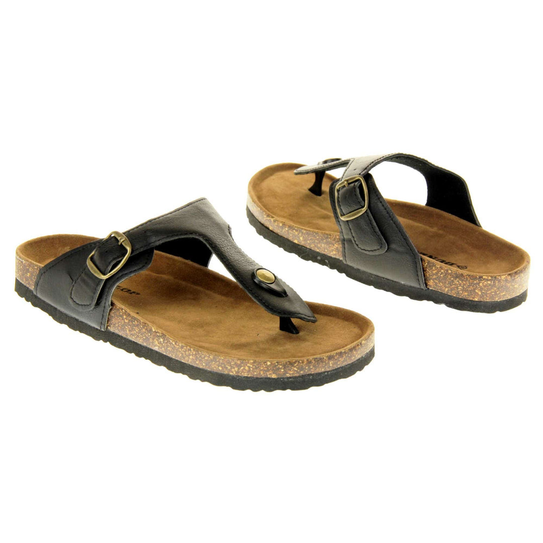 Black buckle sandals. Black faux leather strap with toe post to the front and gold buckle to the outside. Soft tan faux suede footbed with cork effect outsole and black sole. Both feet at an angle facing top to tail.