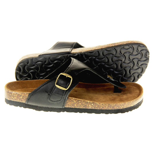 Black buckle sandals. Black faux leather strap with toe post to the front and gold buckle to the outside. Soft tan faux suede footbed with cork effect outsole and black sole. Both feet from a side profile with the left foot on its side behind the the right foot to show the sole.