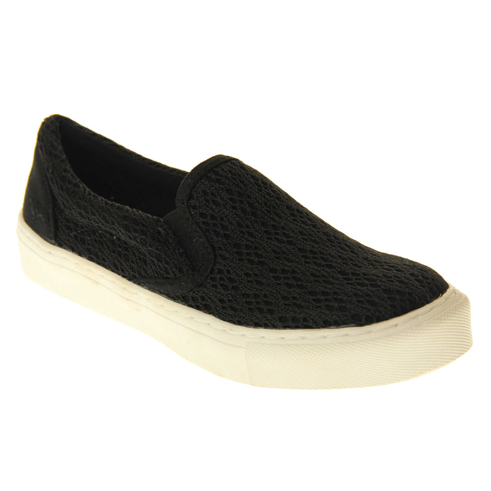 Black crochet shoes. Slip on plimsoll style shoes with a black canvas upper with a crochet overlay. Black elasticated gusset. White flat platform sole. Right foot at an angle.
