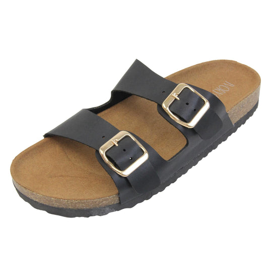 Black double strap sandals. Womens dual strap slip on sandals. With a black synthetic leather upper with a gold buckle on each strap. Brown faux suede insole with a moulded footbed. Cork effect outsole with black base with grip to the bottom. Left foot at an angle.