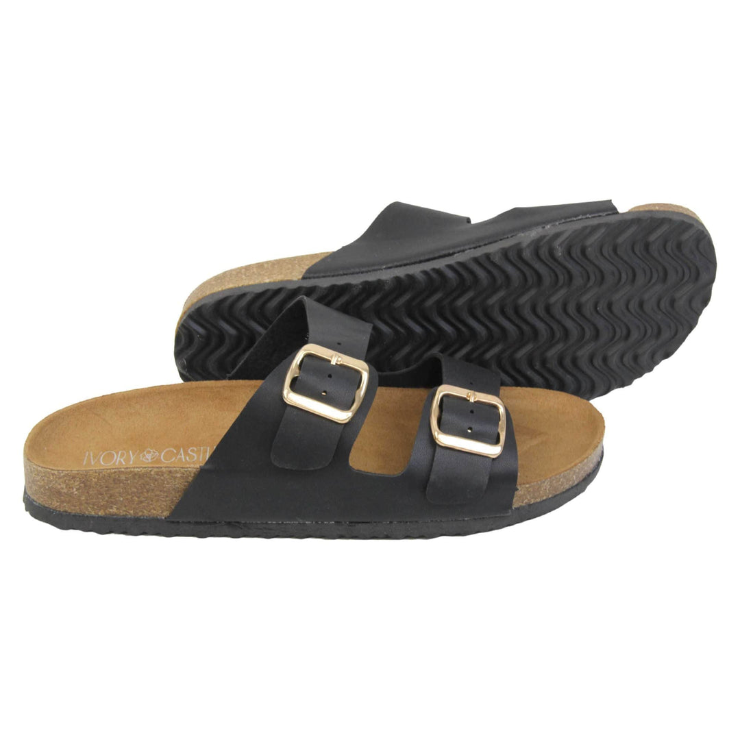 Black double strap sandals. Womens dual strap slip on sandals. With a black synthetic leather upper with a gold buckle on each strap. Brown faux suede insole with a moulded footbed. Cork effect outsole with black base with grip to the bottom. Both feet from a side profile with the left foot on its side behind the the right foot to show the sole.