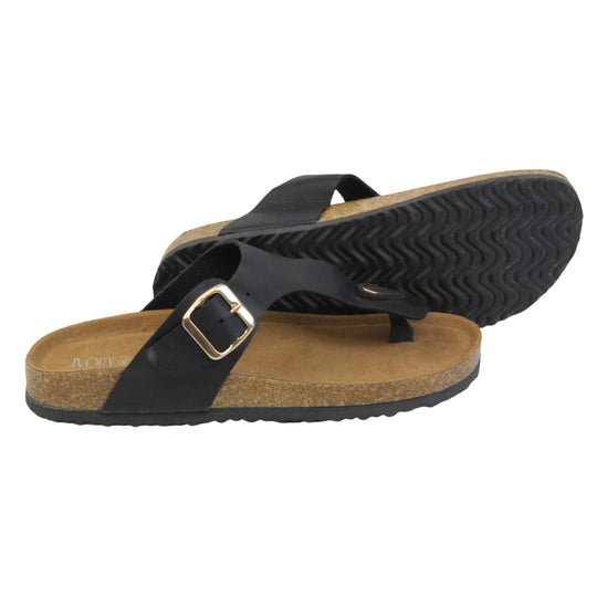 Black faux leather sandals. Black faux leather strap with toe post to the front and gold buckle to the outside. Soft tan faux suede footbed with cork effect outsole and black sole. Both feet from a side profile with the left foot on its side behind the the right foot to show the sole.