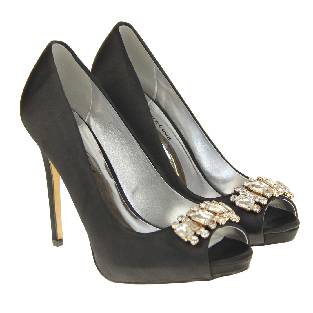 Black peep toe shoes. Classic women's peep toe high heels with a black satin upper. Metallic silver insole with Sabatine branding. Black satin stiletto heel with a cream sole. Diamante cluster detailing across the toes. Both feet together at a slight angle.