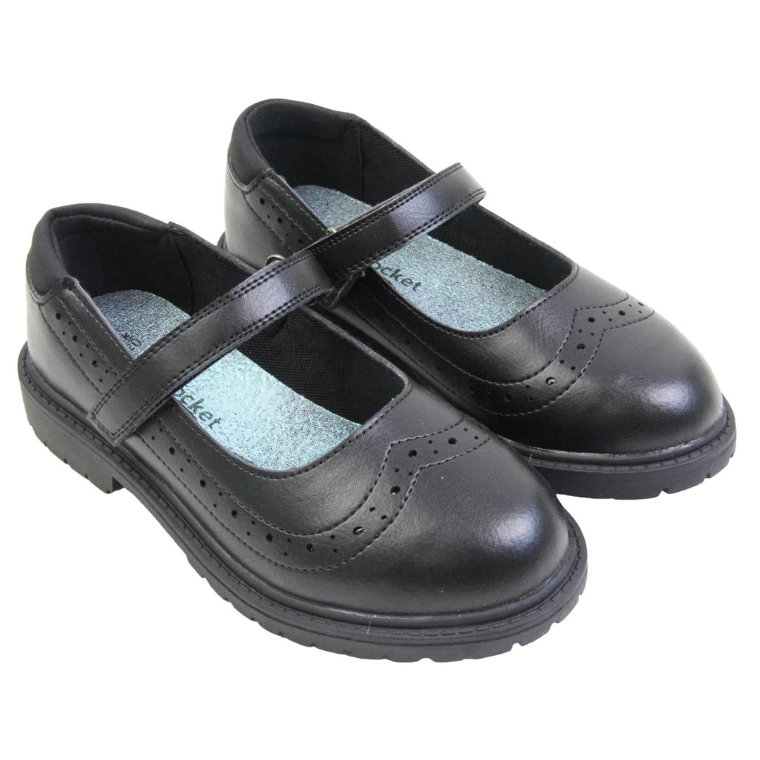 Black school shoes for teenage girls. Mary Jane style shoes with black faux leather uppers. With a touch fasten strap over the foot and brogue detailing around the top of the shoe. Black textile lining with a metallic blue insole. Chunky black sole with slight heel. Both feet together at an angle.