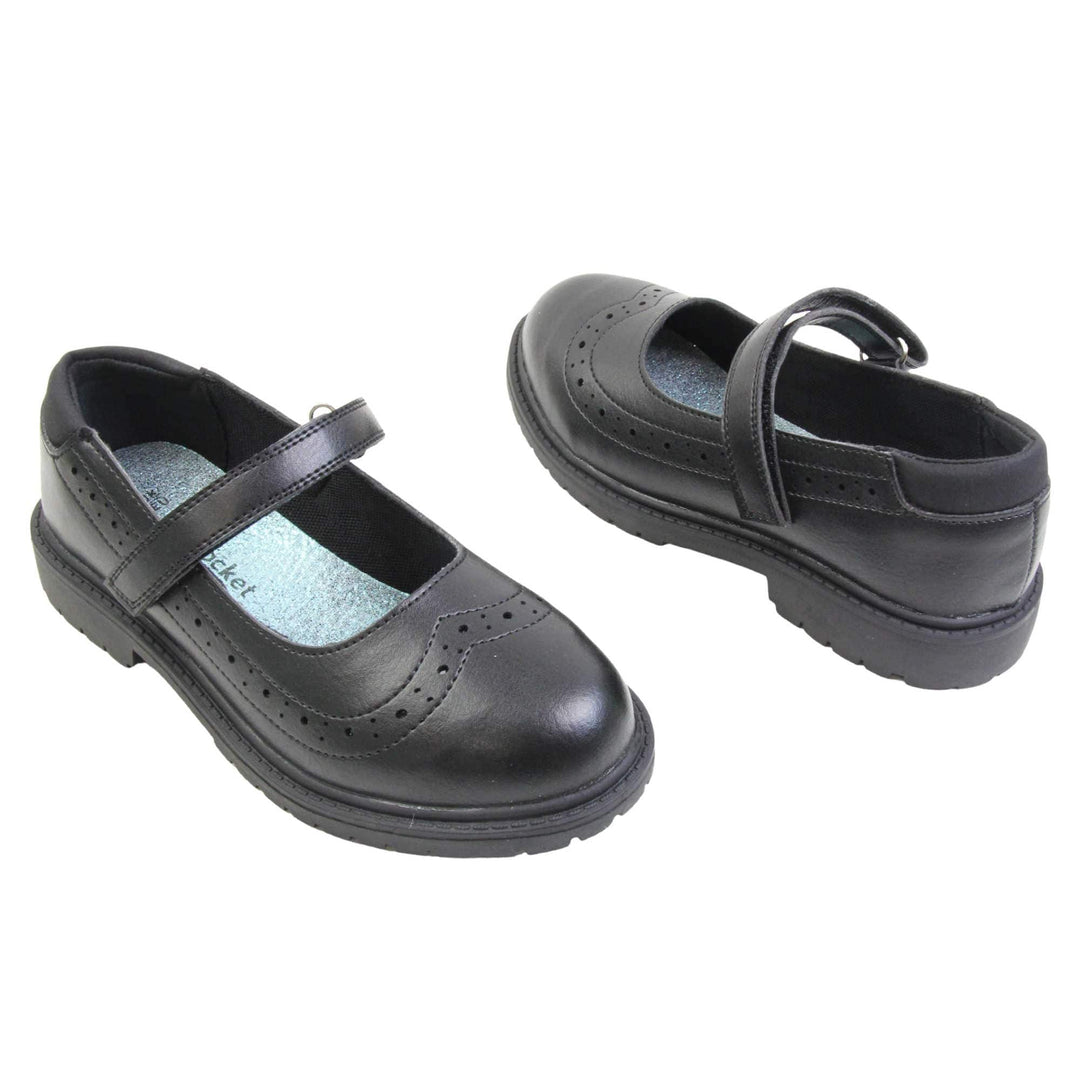 Black school shoes for teenage girls. Mary Jane style shoes with black faux leather uppers. With a touch fasten strap over the foot and brogue detailing around the top of the shoe. Black textile lining with a metallic blue insole. Chunky black sole with slight heel. Both feet at an angle facing top to tail.