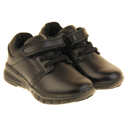 Black School Shoes. Matt black coated leather trainer shoes. With black sole and elasticated lace detailing and touch fastening strap to the top. Both shoes next to each other
