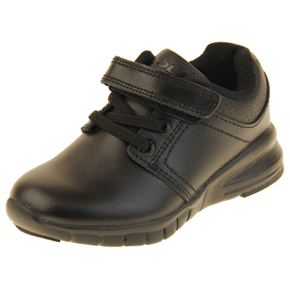 Black School Shoes. Matt black coated leather trainer shoes. With black sole and elasticated lace detailing and touch fastening strap to the top. Left foot at an angle
