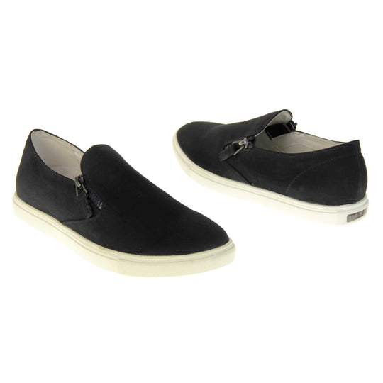 Black slip on pumps. Women's shoes with a black faux leather upper and zip detailing down the side of the tongue. White real leather lining. Thick white sole. Both feet at an angle facing top to tail.