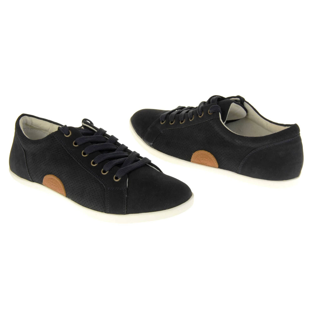Black suede trainers. Women's shoes in a sneaker style with a black faux suede upper. Tiny dot cut-out detailing to the side of the shoe. Black laces and a brown half-circle to the side of the shoe with Keddo branding on it. White leather lining and sole. Both feet at an angle facing top to tail.