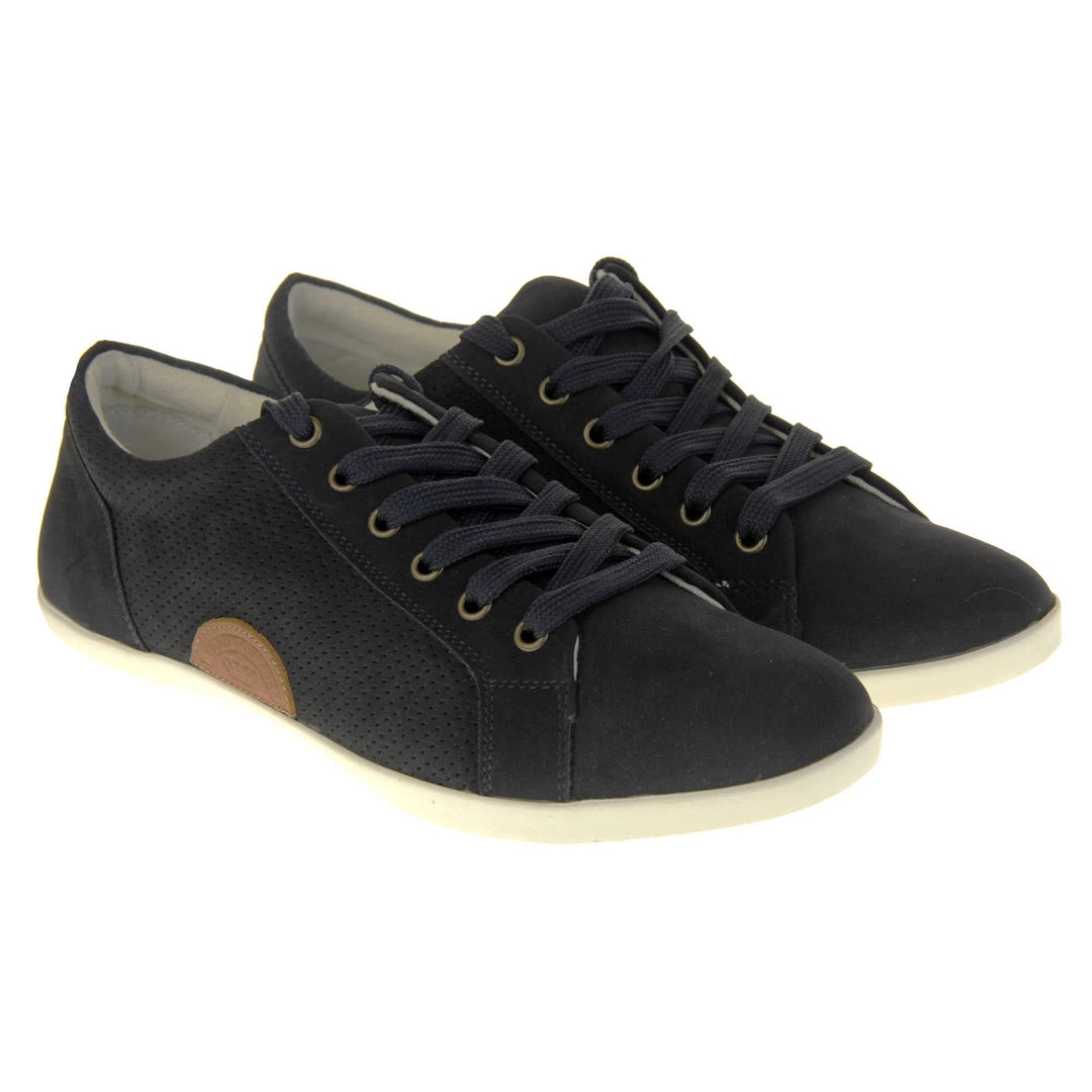 Black suede trainers. Women's shoes in a sneaker style with a black faux suede upper. Tiny dot cut-out detailing to the side of the shoe. Black laces and a brown half-circle to the side of the shoe with Keddo branding on it. White leather lining and sole. Both feet together at a slight angle.