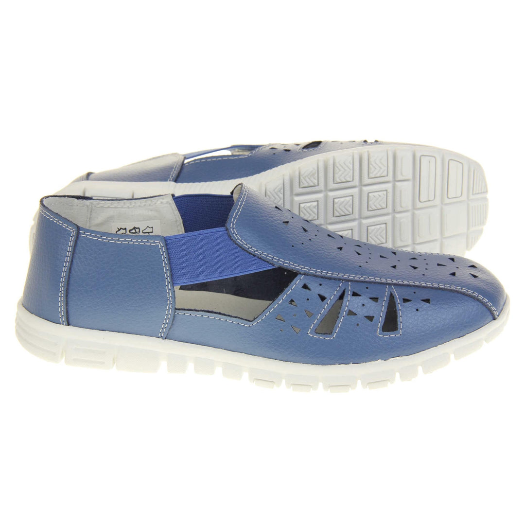 Blue wide fit sandals. Womens classic full foot sandal with a blue leather upper. Strappy sides with cut out designs along the side and centre straps. Blue elasticated straps joining the centre to the backs. White insole and leather lining. White sole with grip to the bottom. Both feet from a side profile with left foot on its side behind the right to show the sole.