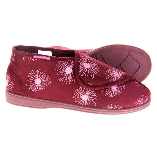 Boot slippers with hard sole. Womens bootie style slipper with a burgundy textile upper with a pink flower print. Touch fasten tab to the top and red textile lining. Firm red sole. Both feet from a side profile with the left foot on its side behind the the right foot to show the sole.