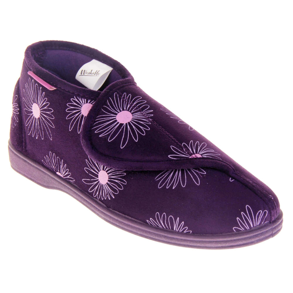 Bootie slippers. Womens bootie style slipper with a purple textile upper with a pink flower print. Touch fasten tab to the top and purple textile lining. Firm purple sole. Right foot at an angle.