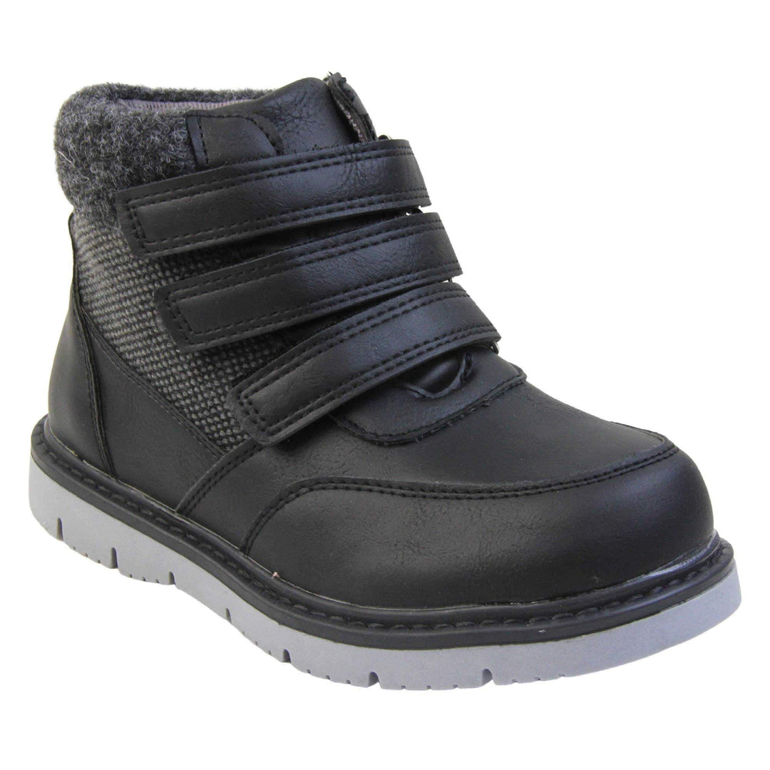 Boys Ankle Boots. Black faux leather upper with textile side panels and black faux fur collar. Three black touch fasten faux leather straps along the front. Grey synthetic sole with grip to the base. Right foot at an angle.