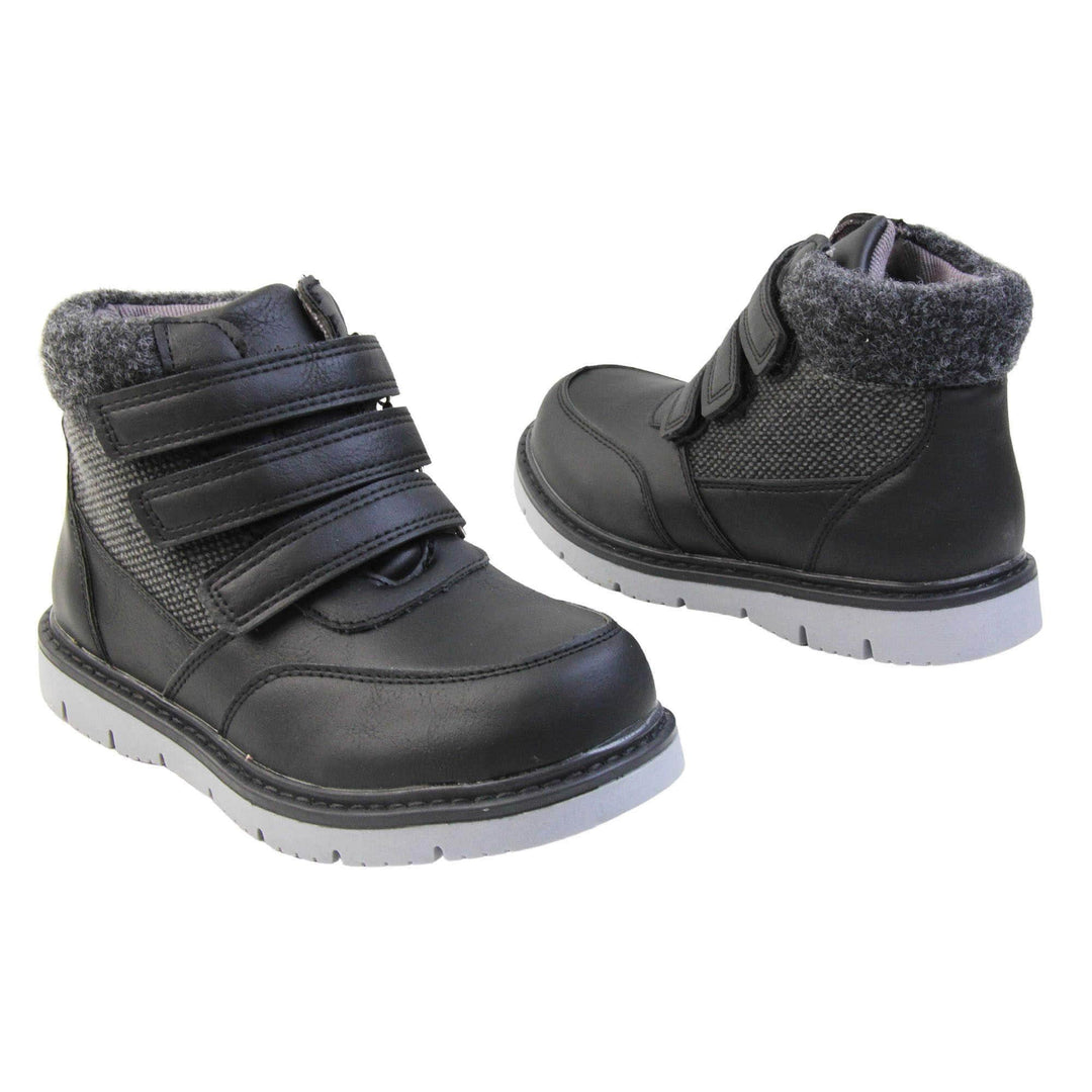 Boys Ankle Boots. Black faux leather upper with textile side panels and black faux fur collar. Three black touch fasten faux leather straps along the front. Grey synthetic sole with grip to the base. Both feet at a slight angle facing top to tail.