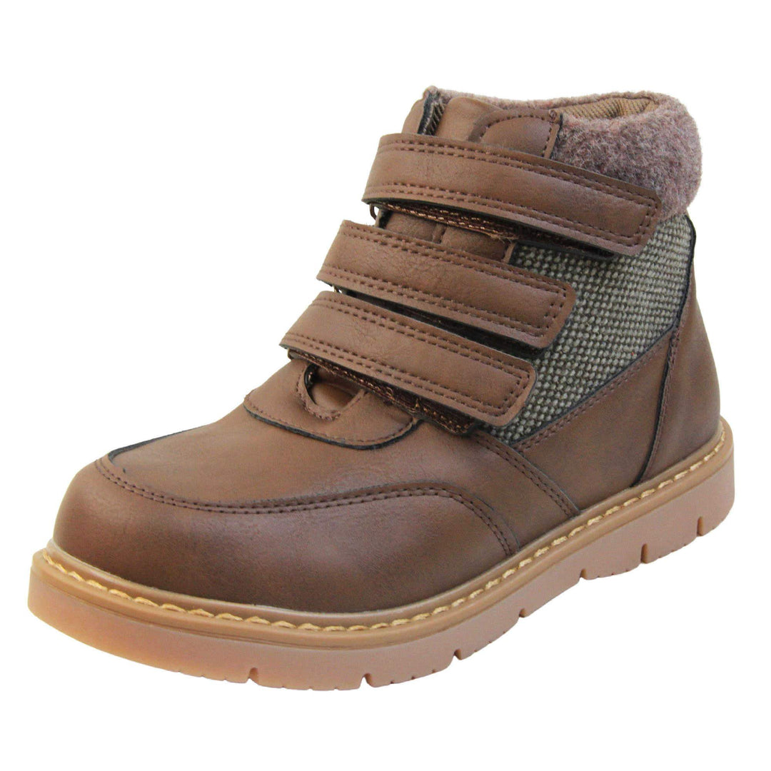 Boys Ankle Boots. Brown faux leather upper with textile side panels and brown faux fur collar. three brown touch fasten faux leather straps along the front to fasten boot. Tan coloured synthetic sole with grip to the base. Left foot at an angle.