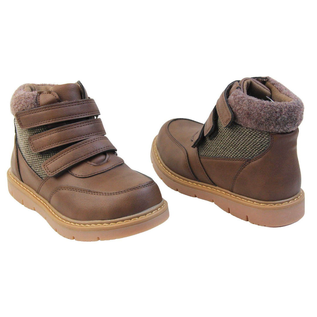 Boys Ankle Boots. Brown faux leather upper with textile side panels and brown faux fur collar. three brown touch fasten faux leather straps along the front to fasten boot. Tan coloured synthetic sole with grip to the base. Both feet at a slight angle facing top to tail.
