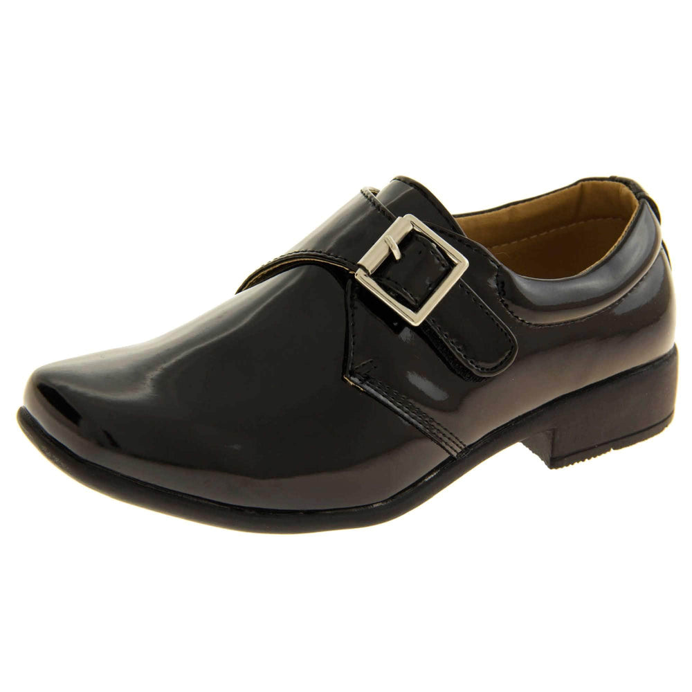 Boys Formal Shoes. Black patent monk style shoes with a buckle effect touch close fastening and a black sole. Left foot at an angle
