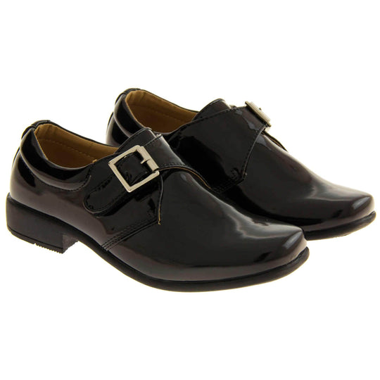 Boys Formal Shoes. Black patent monk style shoes with a buckle effect touch close fastening and a black sole. Both feet next to each other