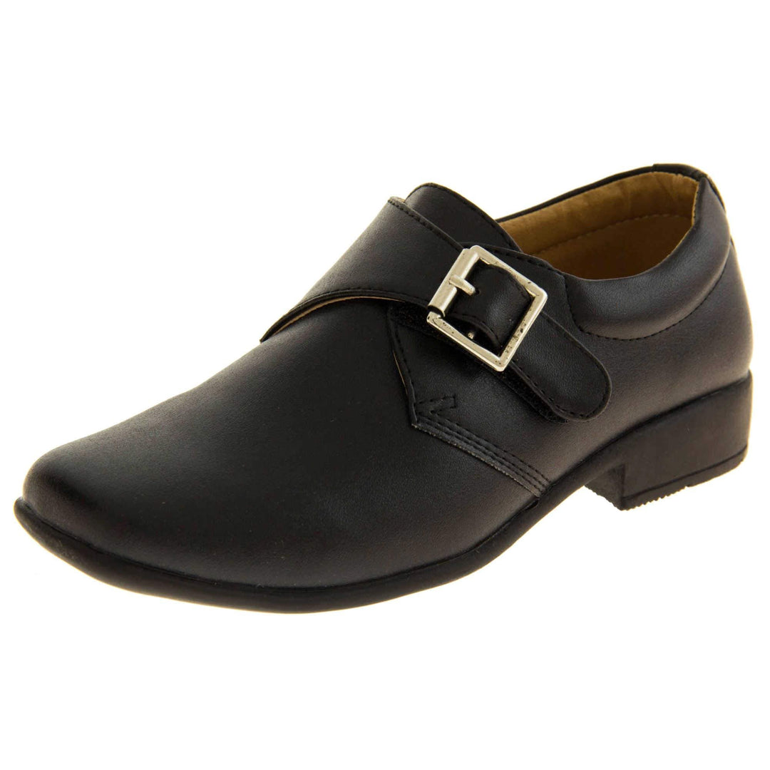 Boys Formal Shoes. Black matt monk style shoes with a buckle effect touch close fastening and a black sole. Left foot at an angle