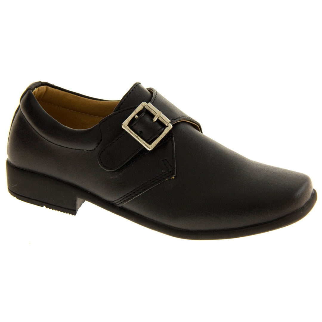 Boys Formal Shoes. Black matt monk style shoes with a buckle effect touch close fastening and a black sole. Right foot at an angle
