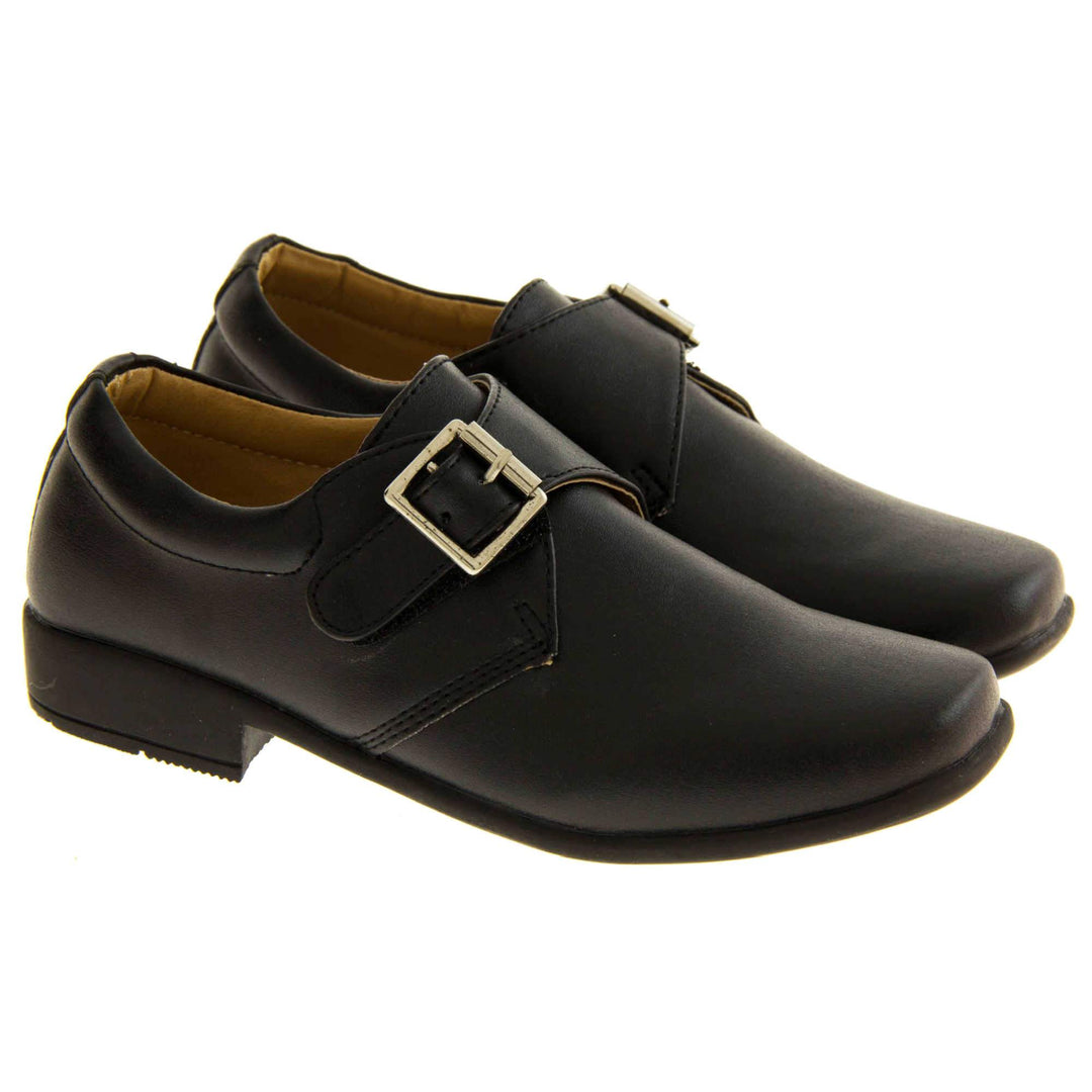 Boys Formal Shoes. Black matt monk style shoes with a buckle effect touch close fastening and a black sole. Both feet next to each other