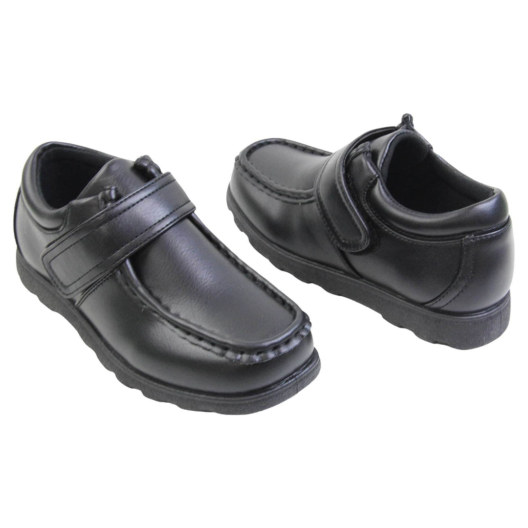 Boys smart school shoes. Black low top shoes with faux leather uppers. Stitching detail with a squared toe and a touch fasten strap over the top of the shoe. Black textile lining with light blue insole and black sole with chunky grip. Both feet at an angle facing top to tail.