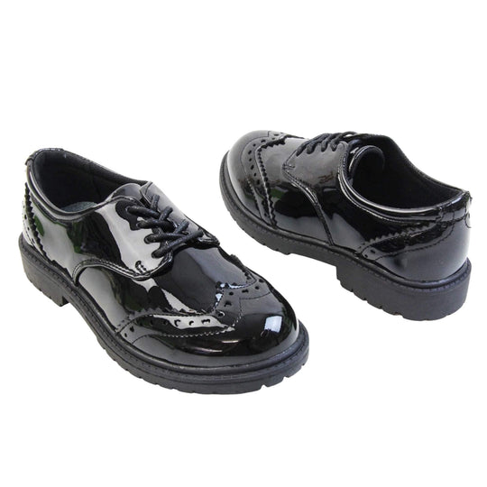 Brogue school shoes. Black patent faux leather uppers in a brogue style shoe. Black laces and lining with metallic blue insole. Black sole with very slight heel. Both feet at an angle facing top to tail.
