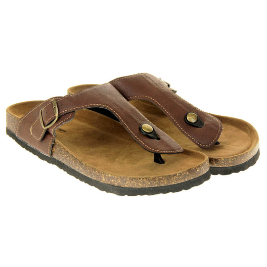 Brown buckle sandals. Dark brown faux leather strap with toe post to the front and gold buckle to the outside. Soft tan faux suede footbed with cork effect outsole and black sole. Both feet together at a slight angle.