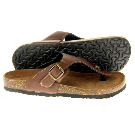 Brown buckle sandals. Dark brown faux leather strap with toe post to the front and gold buckle to the outside. Soft tan faux suede footbed with cork effect outsole and black sole. Both feet from a side profile with the left foot on its side behind the the right foot to show the sole.