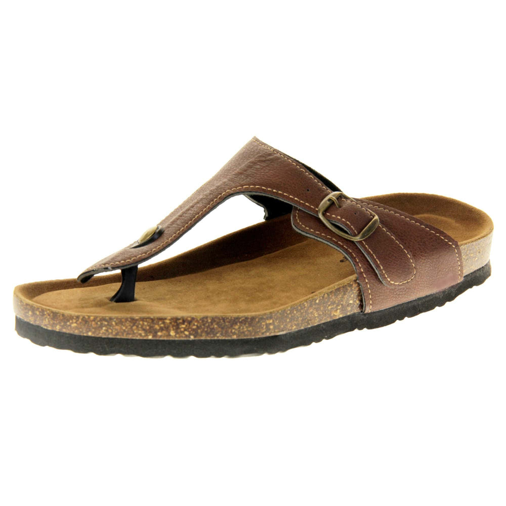 Brown buckle sandals. Dark brown faux leather strap with toe post to the front and gold buckle to the outside. Soft tan faux suede footbed with cork effect outsole and black sole. Left foot at an angle.