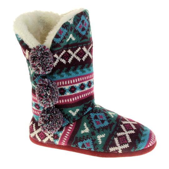 Cable knit slipper boots. Multi coloured patterned knit upper in Aztec style with pom poms to the side, light beige plush faux fur trim and lining. Right foot taken at angle.