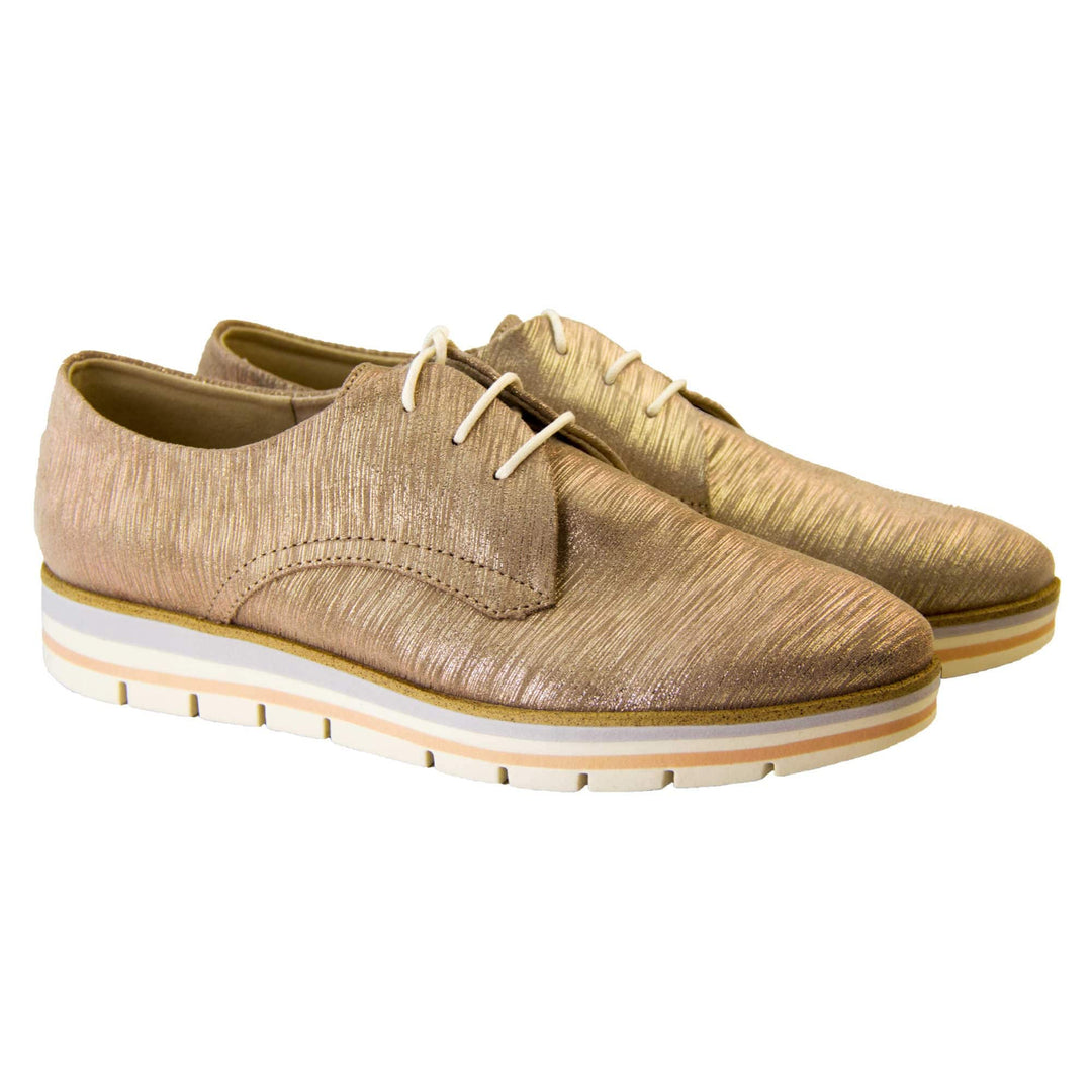 Casual oxfords. Womens oxford style shoes with a taupe metallic faux leather upper. Stitching detail to the sides. Cream laces and beige lining and cream, orange and lilac layered platform sole. Both feet together at a slight angle.