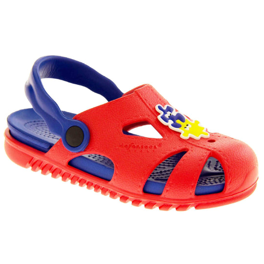 Childrens summers sandals. Fisherman style synthetic sandals with red upper and outer sole. Blue ankle strap and insole. Blue and yellow jigsaw detail to the centre of the upper. Right foot at an angle.