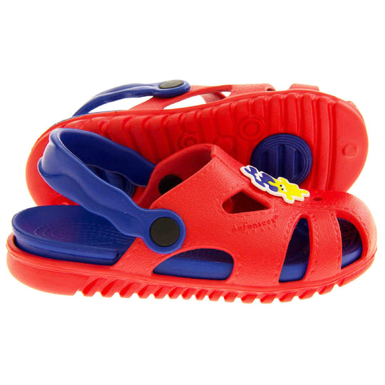 Childrens summers sandals. Fisherman style synthetic sandals with red upper and outer sole. Blue ankle strap and insole. Blue and yellow jigsaw detail to the centre of the upper. Both feet from side profile with left foot on its side to show the sole.