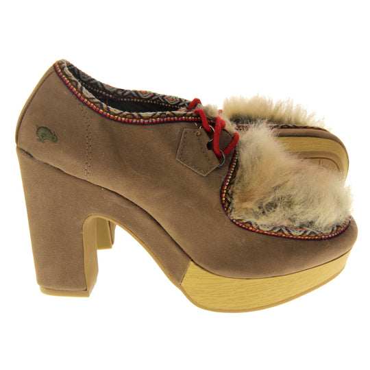 Chunky block heels. Womens bootie style shoe with a brown faux suede upper. Embroidered pattern around the collar and seams. Brown faux fur patch to the front and red laces. Rocket Dog logo to the heel of the bootie. Wood style platform to the front of the shoe with a chunky block heel in brown faux suede to the back. Nude sole. Both feet from a side profile with the left foot on its side behind the the right foot to show the sole.