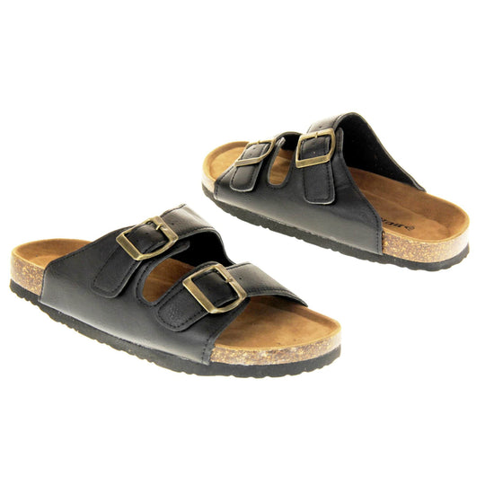 Classic black sandals. Womens dual strap slip on sandals. With a black synthetic leather upper with a gold buckle on each strap. Brown faux suede insole with a moulded footbed. Cork effect outsole with black base with grip to the bottom. Both feet at an angle facing top to tail.