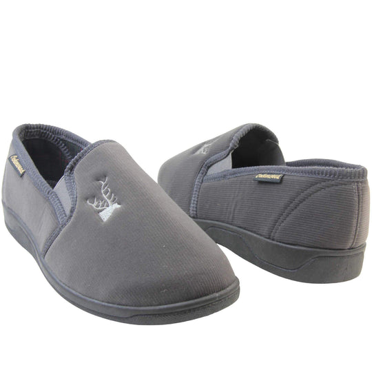 Classic Slippers. Mens full back slippers with a grey velour uppers. Grey elasticated panels joining the tongue to the top of the slippers. Grey stag head detail embroidered onto the top of the upper, near the tongue. Small black label on the outside rim, with Oakenwood branding sewn in gold. Plaid textile lining.  Both feet facing top to tail, at an angle.